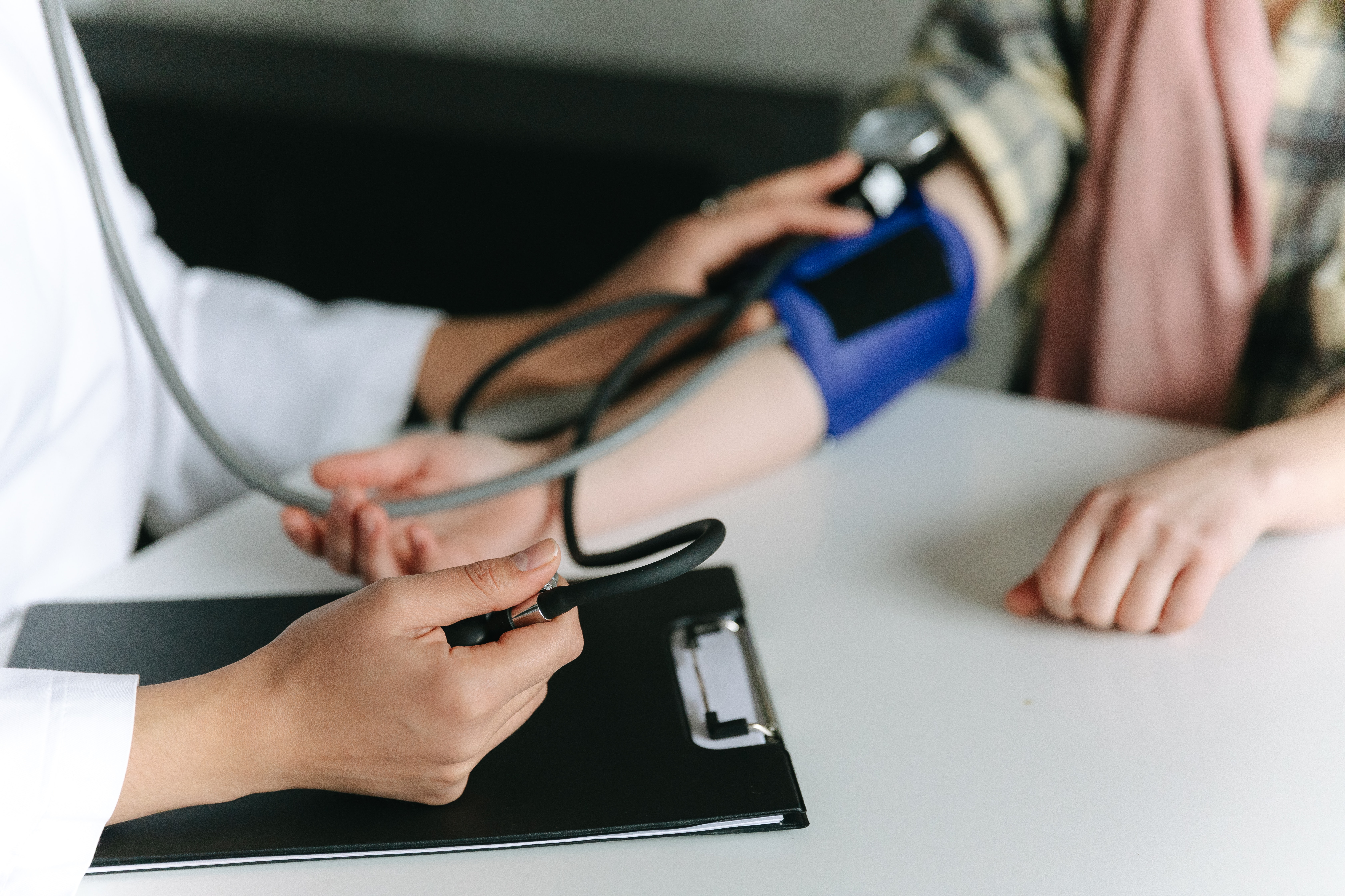 A doctor checks blood pressure for a patient with a chronic condition. This action can also be performed via telehealth.